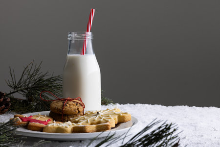Bottle of milk, christmas cookies and copy space on grey background. Sweets, christmas, tradition and celebration concept.の写真素材