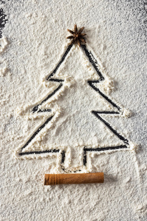 Vertical image of anis seed and christmas tree shape in flour with copy space on black background. Sweets, christmas, tradition and celebration concept.の写真素材