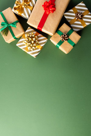 Vertical image of christmas presents with copy space on green background. Presents, christmas, tradition and celebration concept.の写真素材