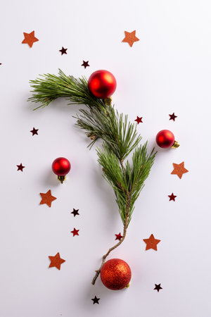 Vertical image of stars, baubles decorations and fir tree branch with copy space on white background. Christmas, decorations, tradition and celebration concept.の写真素材