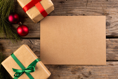 Christmas gifts and decorations with brown card and copy space on wooden background. Christmas, decorations, tradition and celebration concept.の写真素材