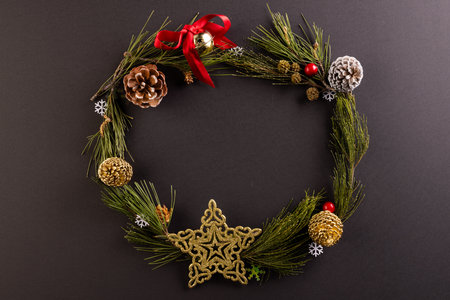 Christmas wreath with baubles and decorations with copy space on black background. Christmas,...