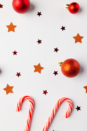 Vartical image of christmas red baubles, stars and candy canes with copy space on white background. Christmas, decorations, tradition and celebration concept.の写真素材