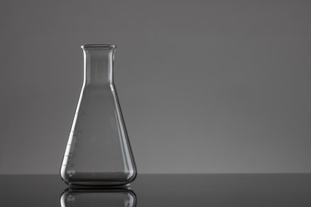 Close up of laboratory beaker and copy space on grey background. Laboratory, science, research and...