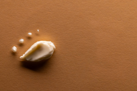 Close up of beauty product white cream smudge and dots with copy space on brown background. Health and beauty, beauty product, make up and colour concept.の写真素材