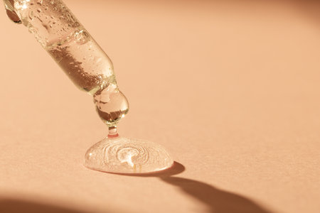 Close up of pipette with drop and copy space on pink background. Health and beauty, beauty product, make up and colour concept.の写真素材