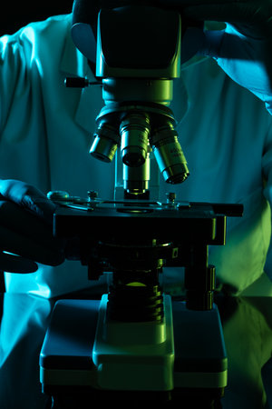 Vertical image scientist using microscope and copy space on black background. Laboratory, science,...