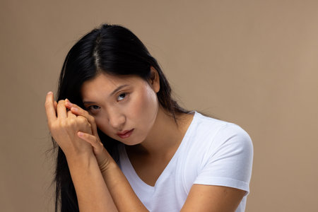 Portrait of asian woman wearing natural makeup and white t-shirt on beige background. Cosmetics,...