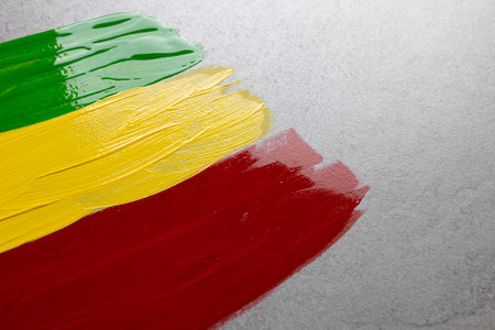 Green, yellow and red paints with copy space on grey stone background. Black history month, africa, black culture and history concept.の写真素材