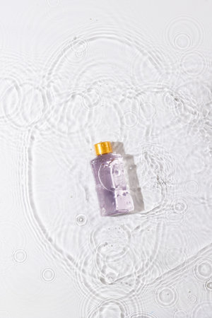 Vertical image of beauty product bottle in water with copy space background on white background....
