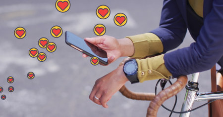 Multiple heart icons floating against mid section of woman with bicycle using smartphone. social media networking and technology conceptの写真素材