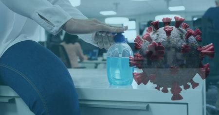 Image of covid-19 cell spinning with man disinfecting hands in office. Healthcare and protection...