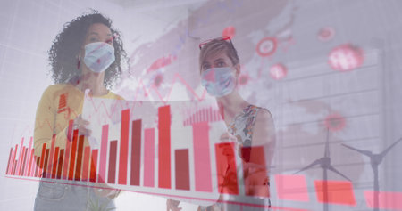Image of digital interface showing statistics with colleagues in office wearing face masks....