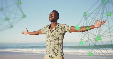 Image of spinning networks with social media digital icons over smiling man on beach. digital interface, social media and global networking concept digitally generated image.の写真素材