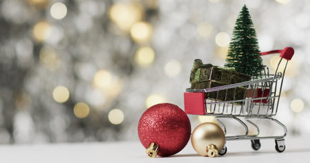 A miniature shopping cart holds holiday decorations. Festive ornaments symbolize seasonal shopping...