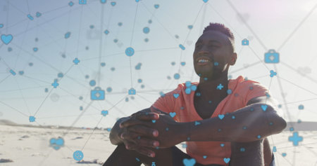 Image of network of connections with digital icons over happy man on beach. digital interface,...