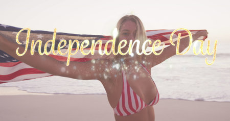 Image of independence day text over smiling woman wrapped in american flag on beach. usa patriotism and democracy concept digitally generated image.の写真素材