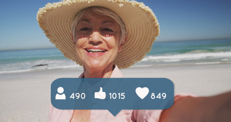 Image of people, thumbs up and heart icons with numbers over senior woman in straw hat on beach....
