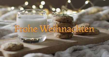 Frohe weihnachten text in orange over christmas cookies and milk with bokeh lights. Christmas, tradition, german, greetings and celebration digitally generated image.の写真素材