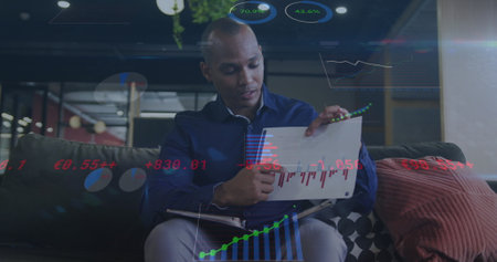 Image of financial data processing over biracial businessman working. Global business, finances,...