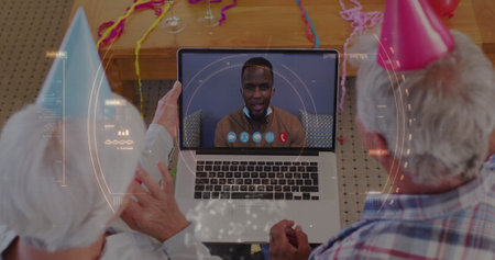 Image of scope scanning over senior couple wearing party hats using laptop on image call in...