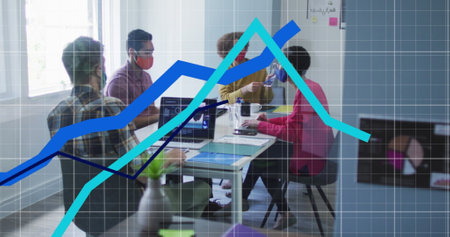 Image of statistics recording with blue lines over team of colleagues wearing face masks. global...