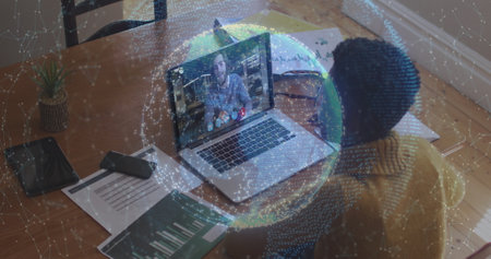 Image of globe of connections over woman using laptop on image call in background. Digital interface global connection and communication concept digitally generated image.の写真素材