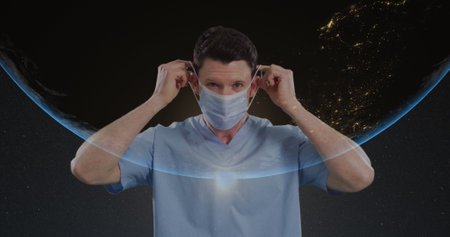 Image of male doctor wearing face mask over globe. global covid 19 pandemic, health and medicine concept digitally generated image.の写真素材