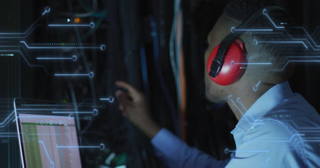 Image of integrated circuits over african american man working on laptop. network, programming, computers and technology concept digitally generated image.の写真素材