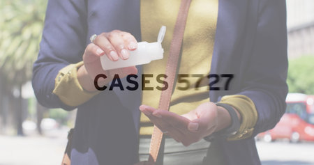 Image of statistics with number of cases over man sanitizing his hands. global covid 19 pandemic, health and medicine concept digitally generated image.の写真素材