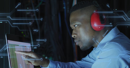 Image of integrated circuits over african american man working on laptop. network, programming,...