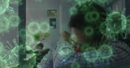 Image of covid 19 cells over man sneezing in office wearing face mask. global covid 19 pandemic, health and medicine concept digitally generated image.の写真素材