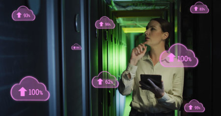 Image of clouds with uploading over caucasian woman working in server room. network, programming, computers and technology concept digitally generated image.の写真素材