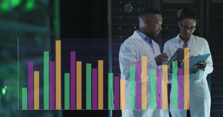 Image of graphs over african american woman and man in server room. network, programming, computers and technology concept digitally generated image.の写真素材