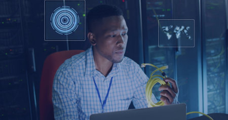 Image of processing circles floating over african american man working in server room. network,...