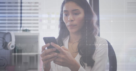 Image of interface with statistics and data with businesswoman using smartphone in office. global communication digital interface concept, digitally generated image.の写真素材