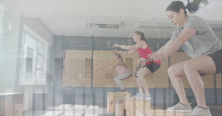 Image of data processing on graph over diverse women jumping on boxes cross training at gym....