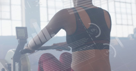 Image of data processing on interface over biracial woman training on rowing machine at gym....