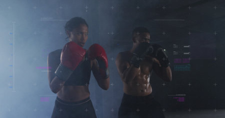 Biracial couple training in a gym, with copy space. They showcase fitness and determination during a boxing workout.の写真素材