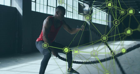 Image of network of connections with economical icons over man exercising with ropes. Digital interface global sport and performance concept digitallygenerated image.の写真素材