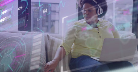 Image of data processing on screens over african american businesswoman in office. Global business, digital interface, computing and data processing concept digitally generated image.の写真素材