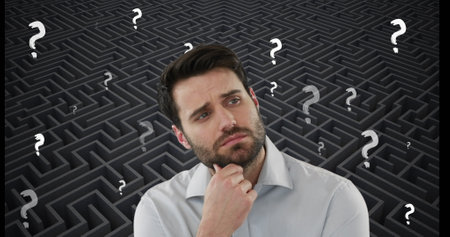 Image of confused caucasian man and white question marks moving over grey maze. Decisions, confusion, education and learning, digitally generated image.の写真素材