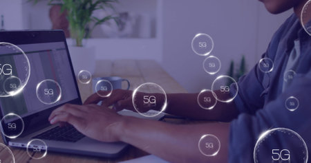 Image of 5g texts over biracial man using laptop. Global business and digital interface concept...