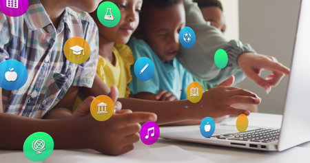 Image of school icons over diverse female teacher and pupils using laptop at desk in class....