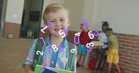 Image of numbers moving over happy caucasian schoolboy smiling in school corridor. School,...