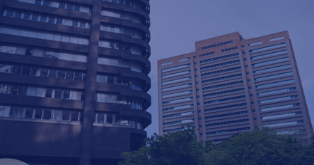Modern office buildings dominate the skyline at dusk. The architecture signifies a bustling business district that thrives after office hours.の写真素材
