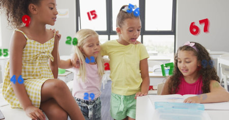 Image of numbers over happy diverse schoolgirls talking in classroom. Friendship, school, education, childhood and learning, digitally generated image.の写真素材