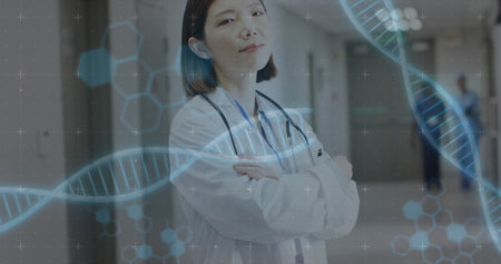 Image of dna strands over asian female doctor. Global medicine, healthcare, digital interface, computing and data processing concept digitally generated image.の写真素材
