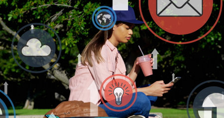 Digital icons and arrows moving upwards against woman using smartphone at park. global networking...