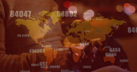 Multiple changing numbers over world map against mid section of man using smartphone on the street. global networking and technology conceptの写真素材